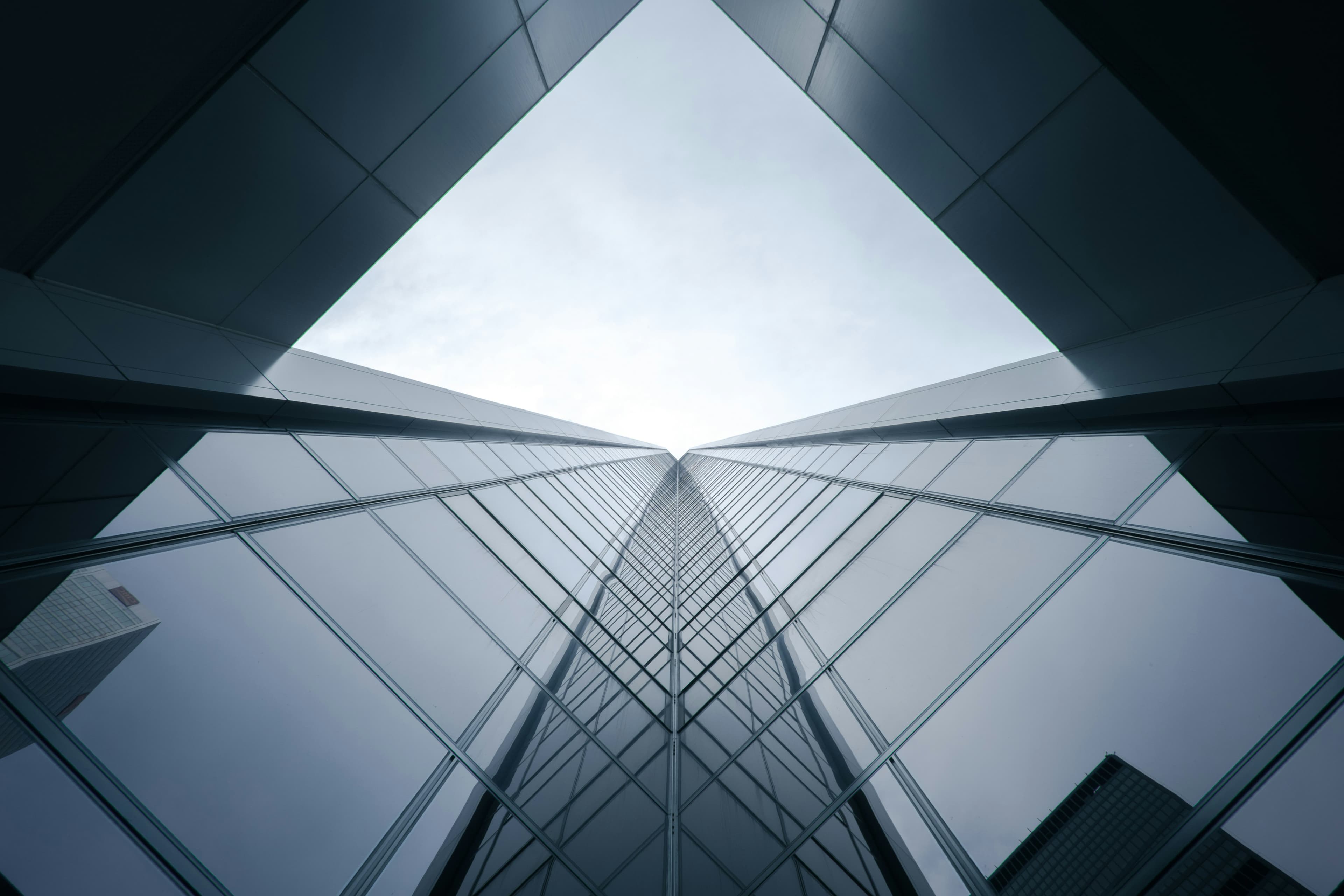 Glass skyscraper with geometric lines — GHST Capital retirement and financial planning